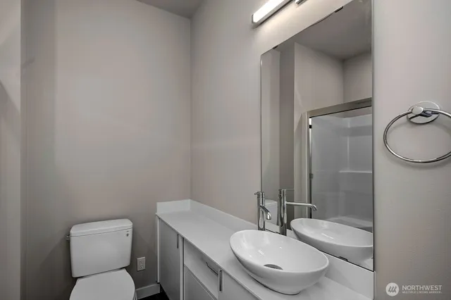 a bathroom with a granite countertop toilet sink and mirror