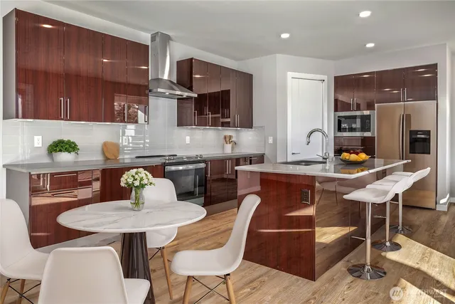 a kitchen with a dining table chairs and refrigerator