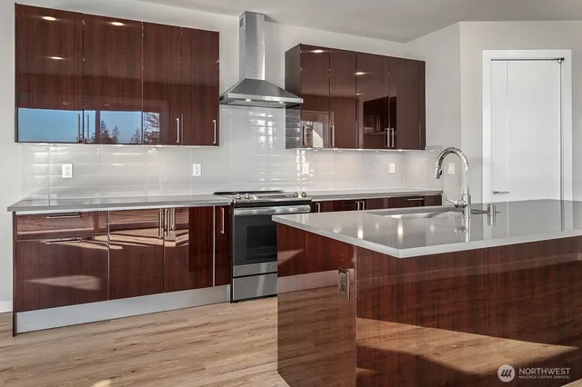 a kitchen with stainless steel appliances granite countertop a sink and a stove