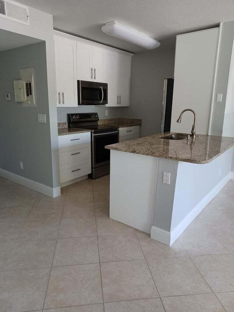 a kitchen with a sink a microwave and refrigerator
