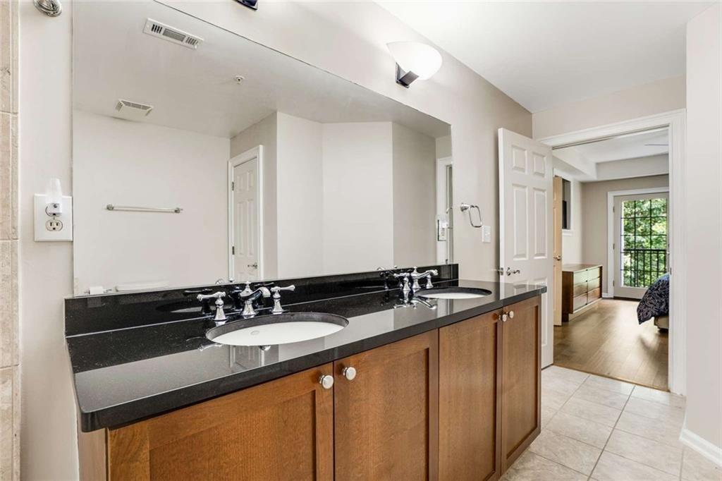 3275 Lenox Road Northeast, Unit 302 Atlanta, GA 30324 - Photo 22 of 50 a en suite bathroom with a sink and a mirror