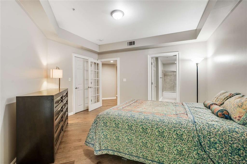 3275 Lenox Road Northeast, Unit 302 Atlanta, GA 30324 - Photo 26 of 50 a spacious bedroom with a bed and a large mirror