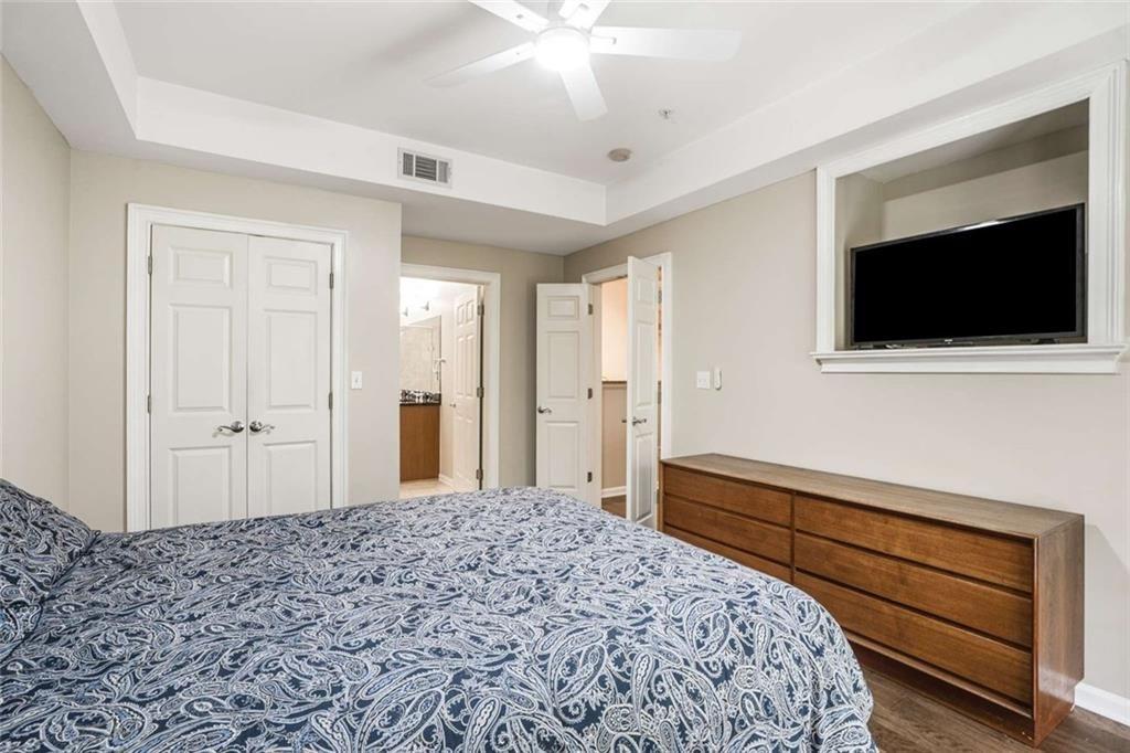 3275 Lenox Road Northeast, Unit 302 Atlanta, GA 30324 - Photo 28 of 50 a bedroom with a bed and a flat screen tv