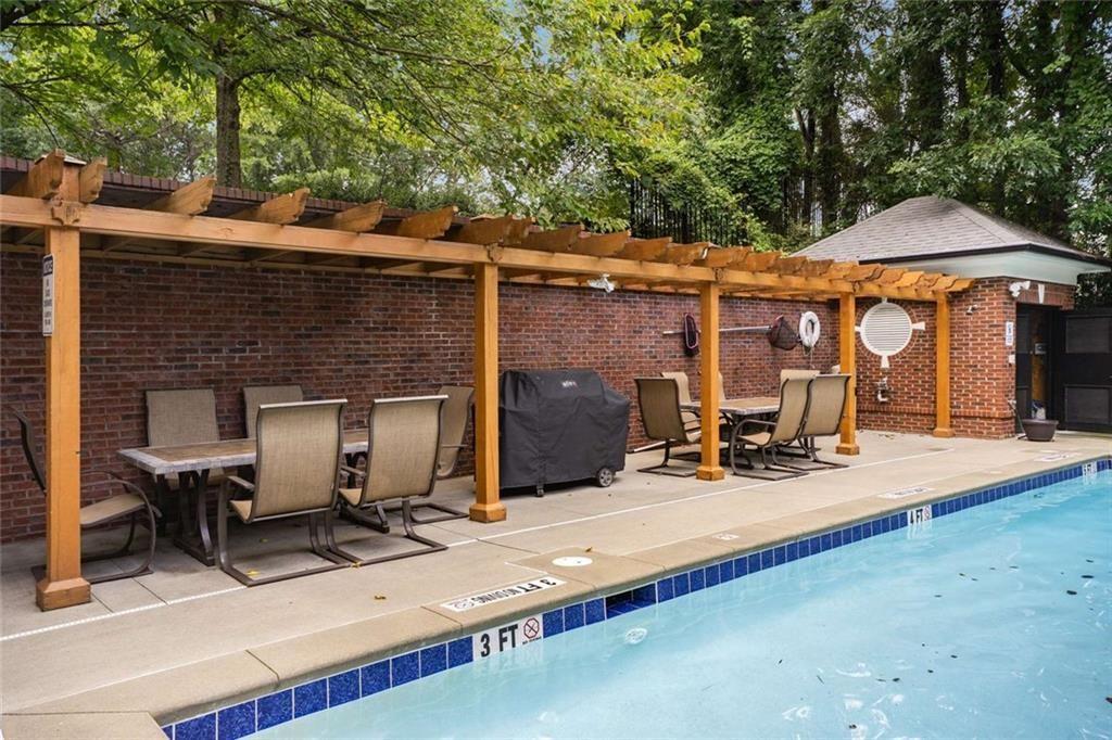 3275 Lenox Road Northeast, Unit 302 Atlanta, GA 30324 - Photo 43 of 50 a view of a patio with table and chairs under an umbrella