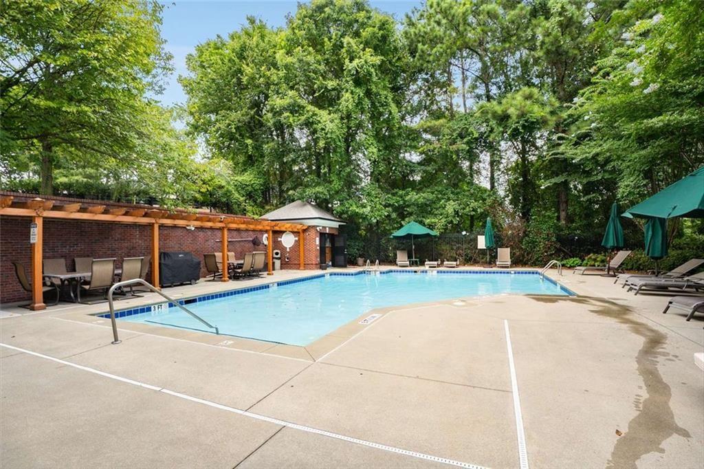 3275 Lenox Road Northeast, Unit 302 Atlanta, GA 30324 - Photo 44 of 50 a view of a patio with table and chairs under an umbrella