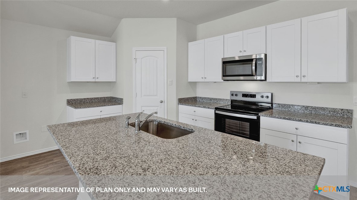 418 Hodges Street Maxwell, TX 78656 - Photo 11 of 32 a kitchen with granite countertop a sink and white cabinets