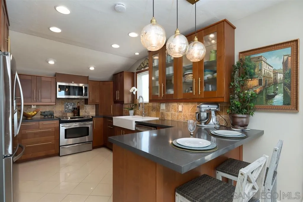 323 Shoemaker Lane Solana Beach, CA 92075 - Photo 5 of 25 a kitchen with a sink stainless steel appliances and dining table
