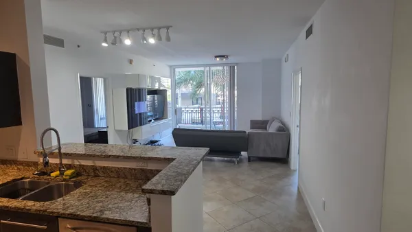 a kitchen with granite countertop a sink and white cabinets