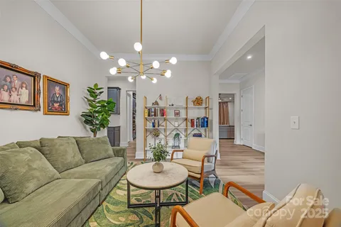 a living room with furniture and a chandelier