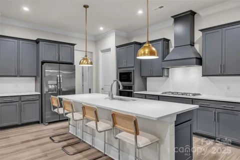 a kitchen with stainless steel appliances granite countertop a sink a stove and refrigerator