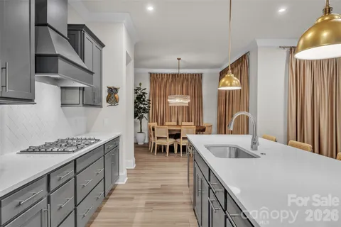 a kitchen with stainless steel appliances granite countertop a sink a stove and refrigerator