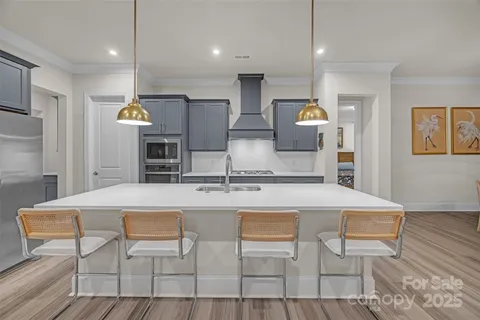 a kitchen with kitchen island wooden cabinets and refrigerator