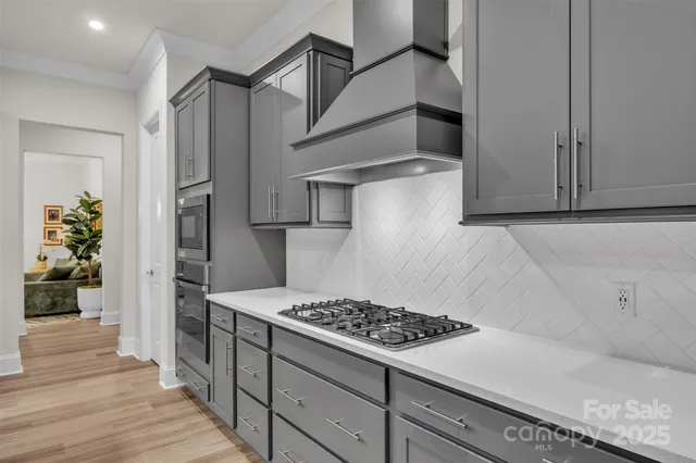 a kitchen with stainless steel appliances granite countertop a refrigerator and a stove top oven