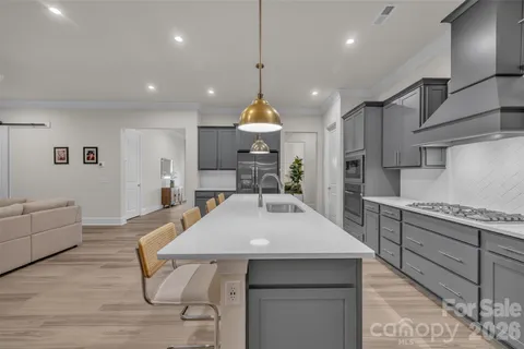 a kitchen with stainless steel appliances granite countertop a refrigerator and a stove top oven