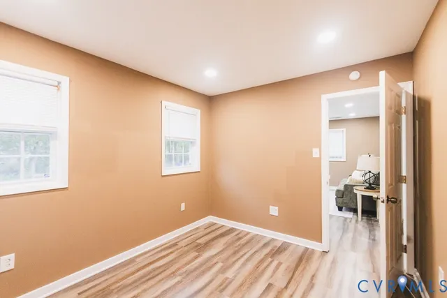 a view of a room with wooden floor and a bathroom