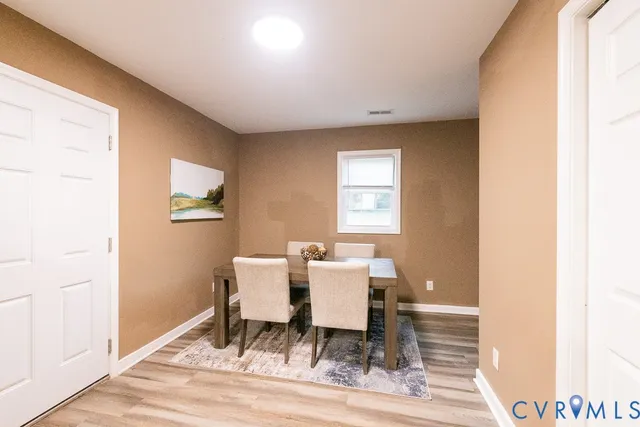 a dining room with wooden floor and a window