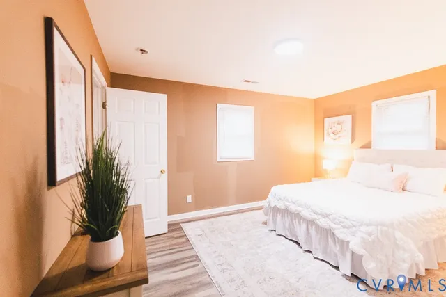 a bedroom with a large bed and a potted plant