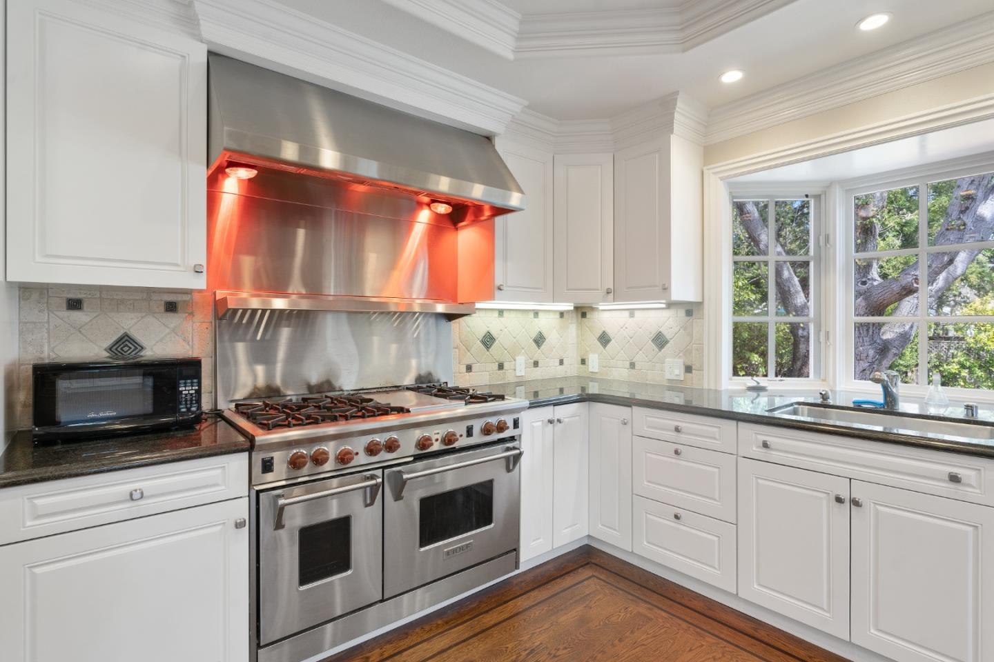 612 Prospect Row San Mateo, CA 94401 - Photo 18 of 54 a kitchen with white cabinets and appliances