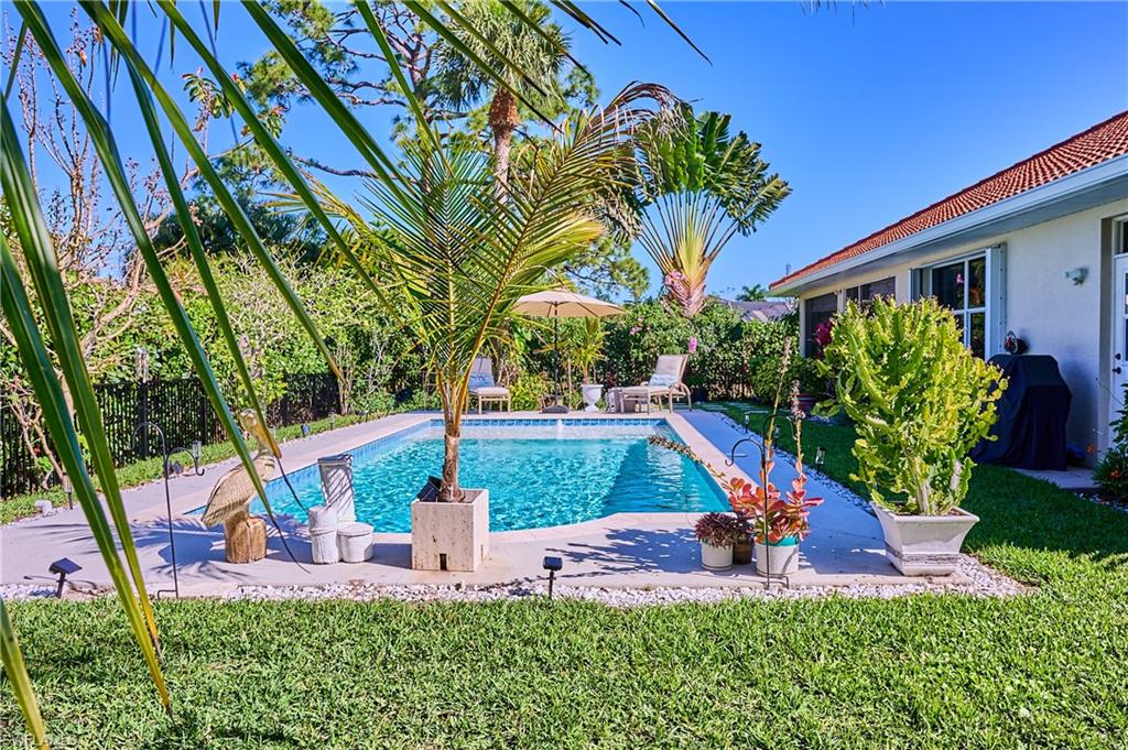 186 Muirfield Circle Naples, FL 34113 - Photo 31 of 36 a view of a backyard with plants and a garden