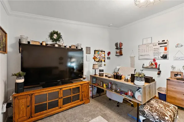 a bedroom with a bed a mirror on dresser and a flat screen tv