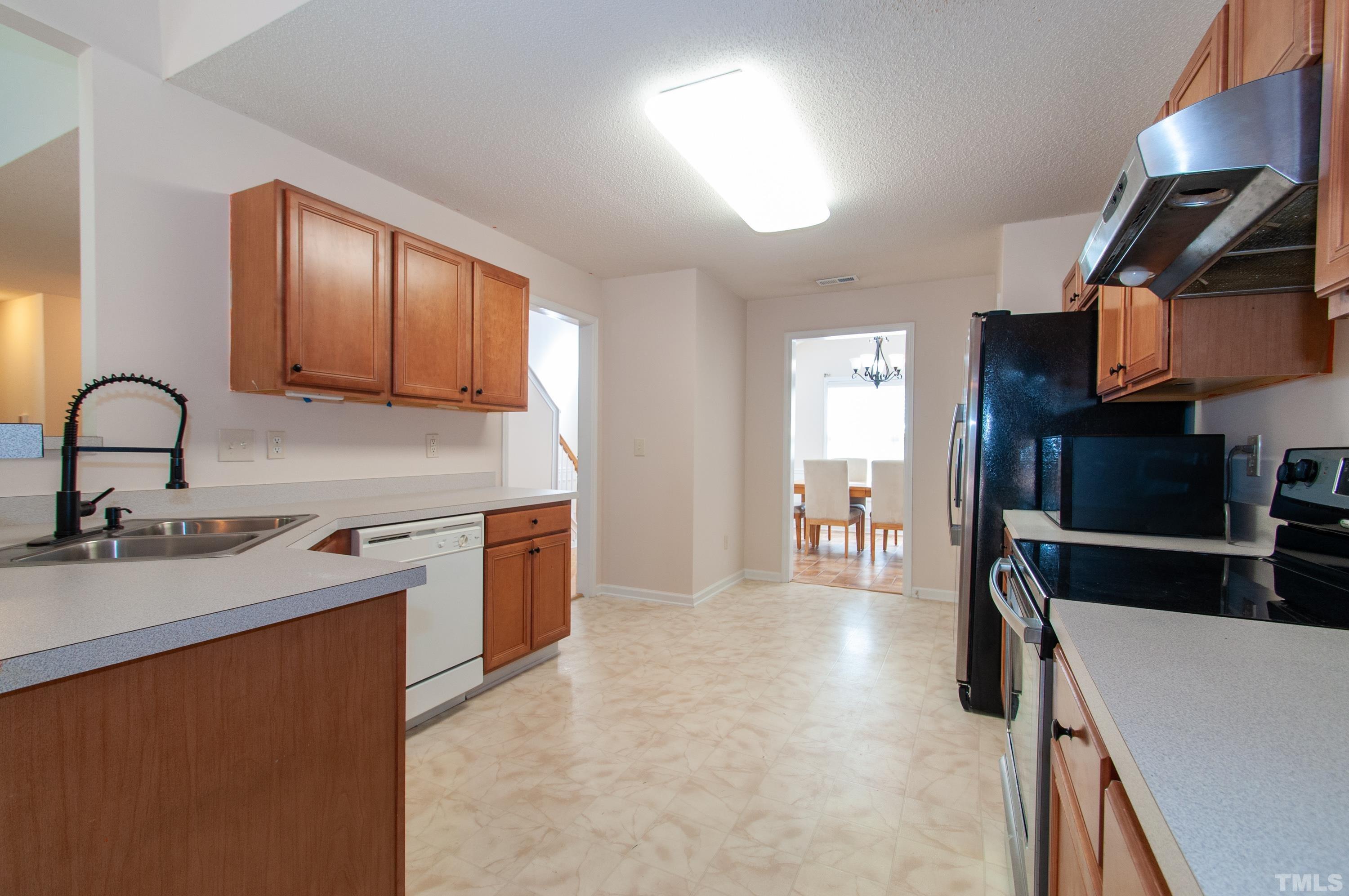 4617 Dresden Village Drive Raleigh, NC 27604 - Photo 12 of 33 a kitchen with stainless steel appliances granite countertop a sink stove and refrigerator