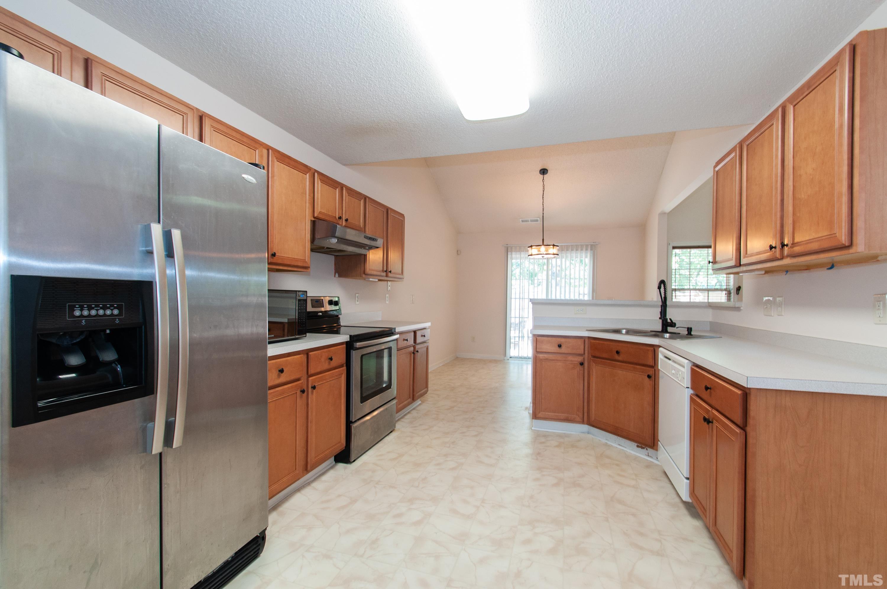 4617 Dresden Village Drive Raleigh, NC 27604 - Photo 10 of 33 a kitchen with stainless steel appliances granite countertop a refrigerator a sink dishwasher a stove with wooden cabinets