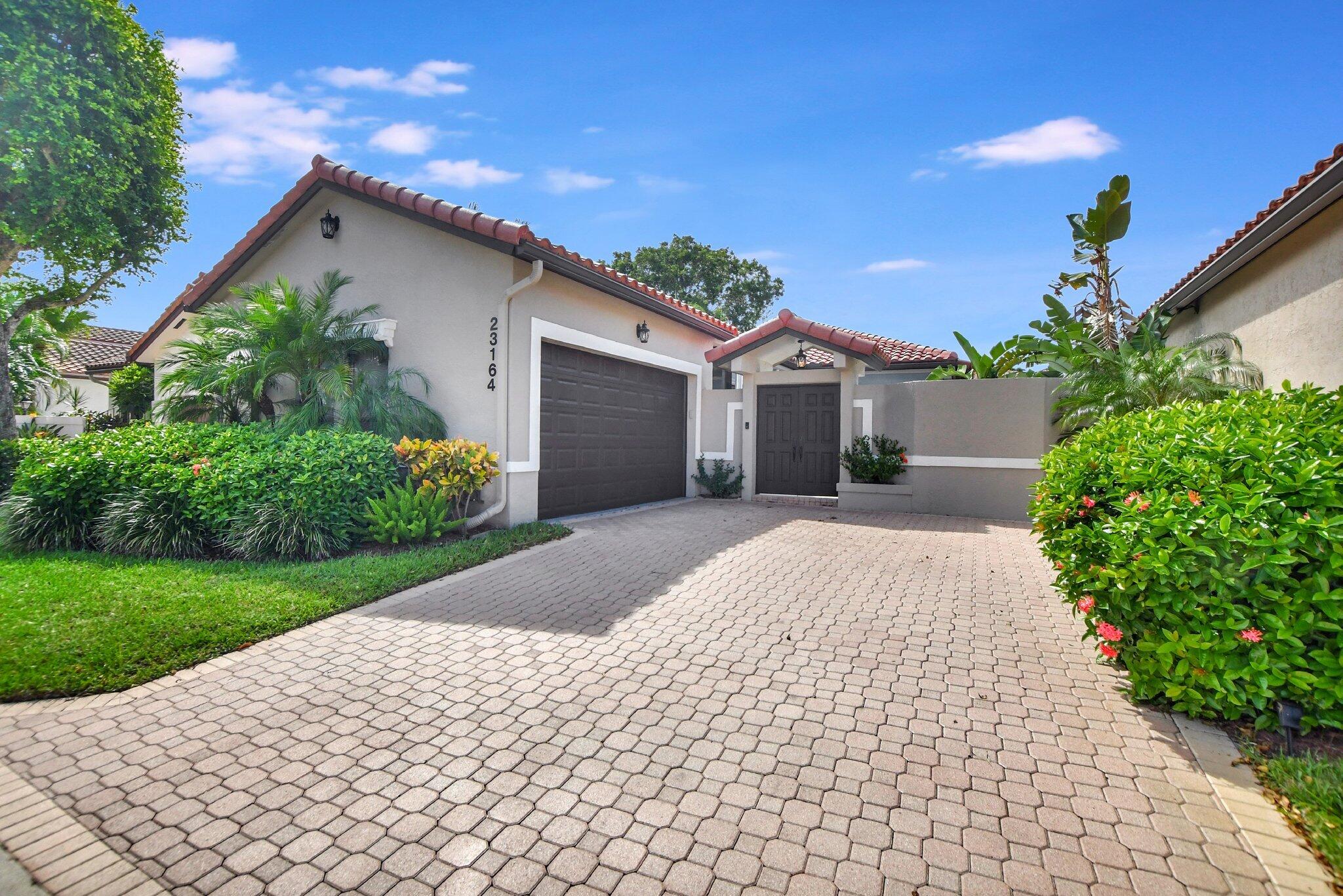 23164 Via Stel Boca Raton, FL 33433 - Photo 1 of 31 a front view of a house with a yard and potted plants