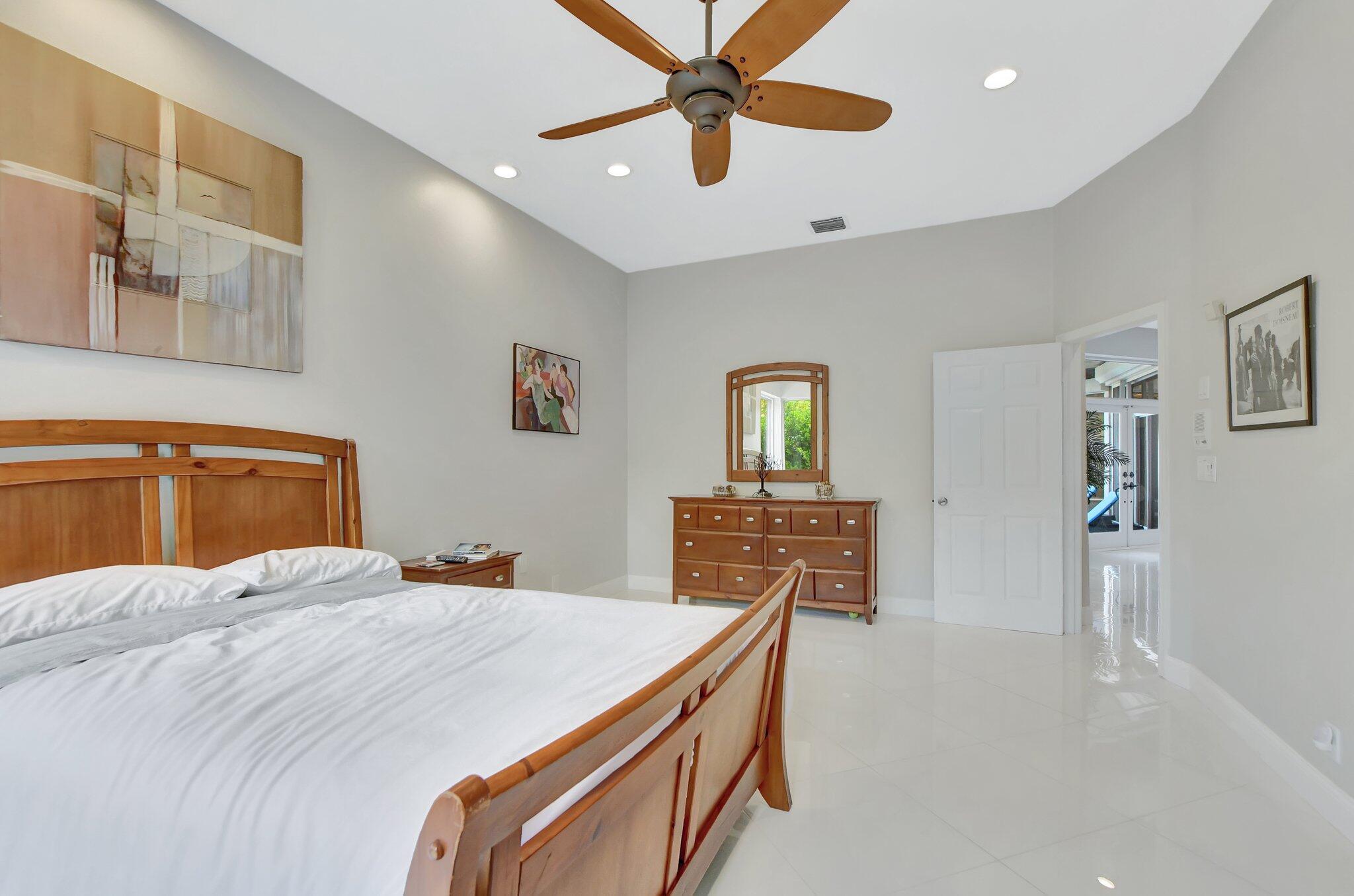23164 Via Stel Boca Raton, FL 33433 - Photo 17 of 31 a bedroom with a bed and a chandelier