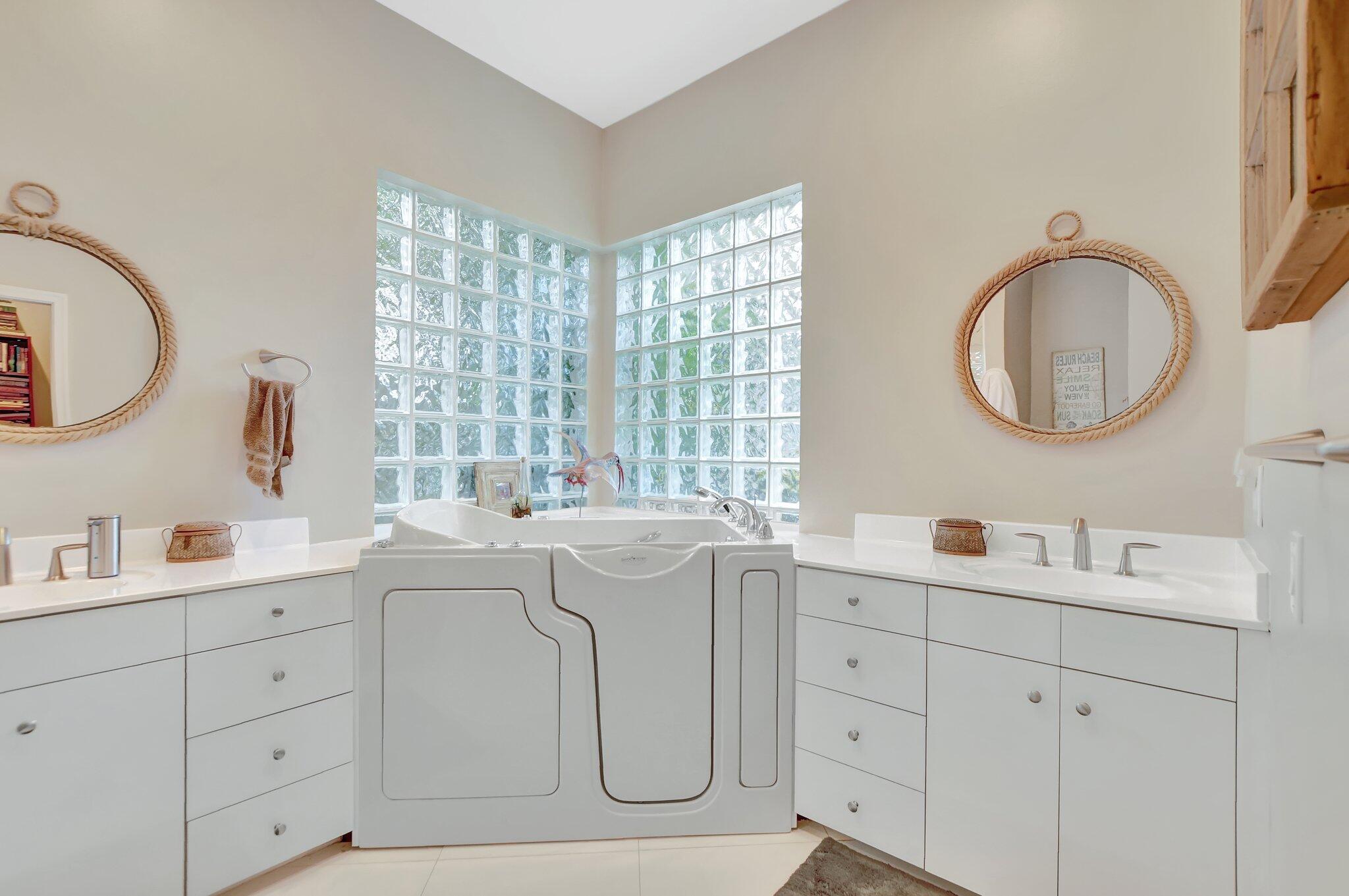 23164 Via Stel Boca Raton, FL 33433 - Photo 20 of 31 a spacious bathroom with double vanity sink a two mirror a window and a bathtub
