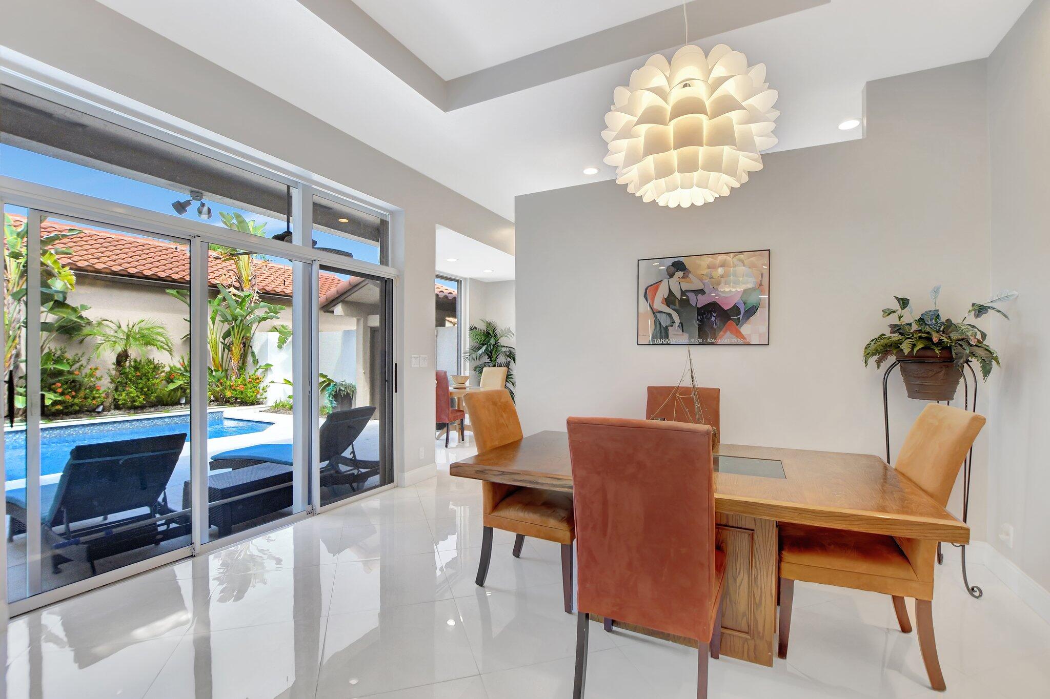 23164 Via Stel Boca Raton, FL 33433 - Photo 7 of 31 a view of a dining room with furniture a chandelier and a large window