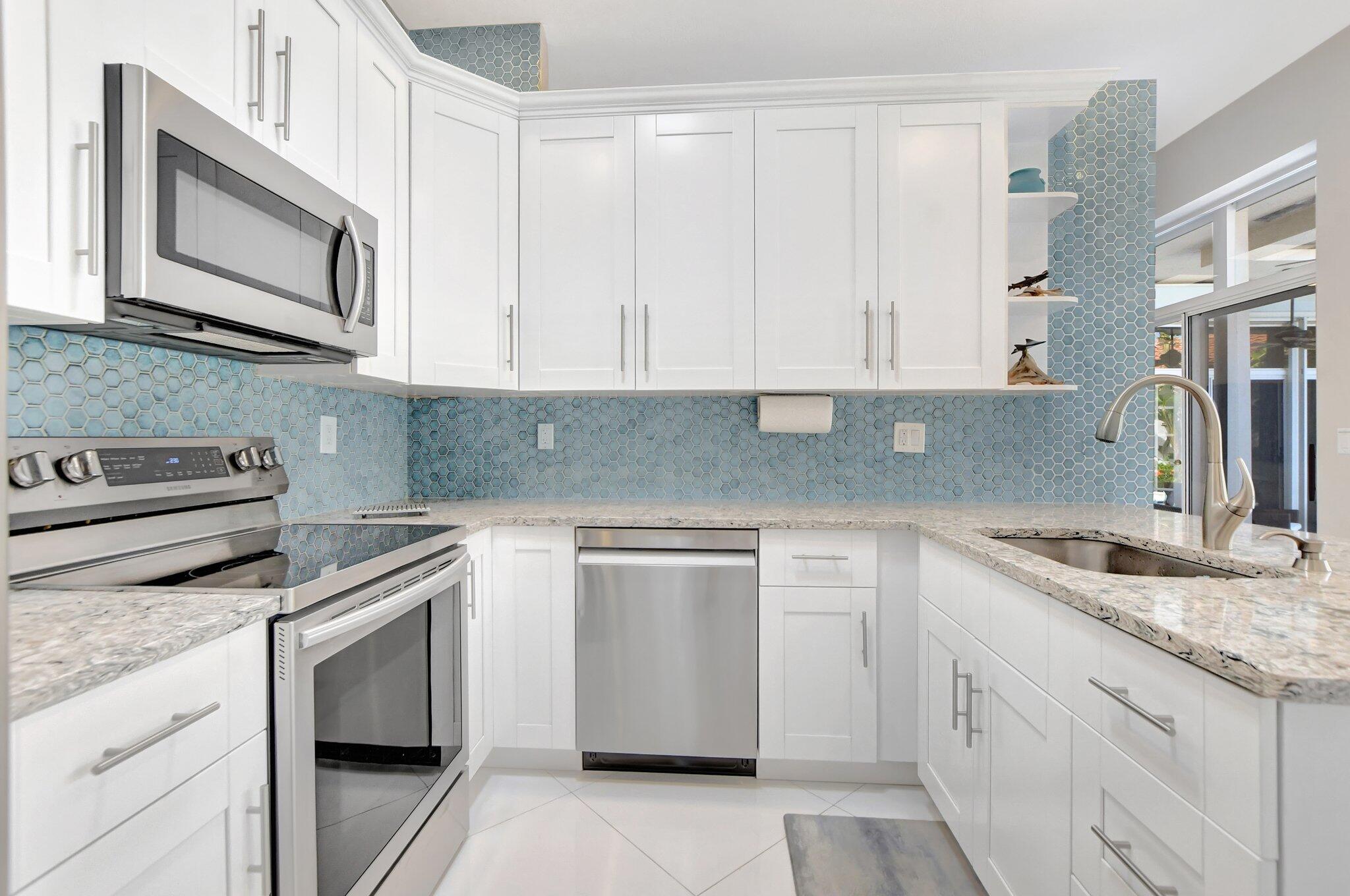23164 Via Stel Boca Raton, FL 33433 - Photo 10 of 31 a kitchen with granite countertop white cabinets and stainless steel appliances