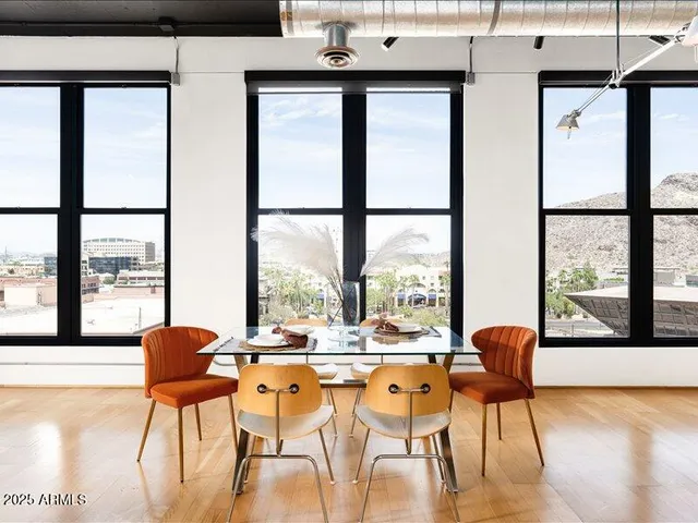 a dining room with furniture and large windows