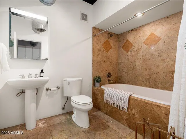 a bathroom with a toilet sink and shower
