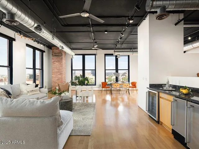 a living room with furniture stove and a large window