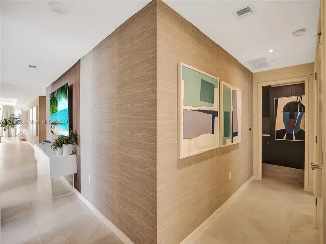 a view of a hallway with a livingroom and furniture