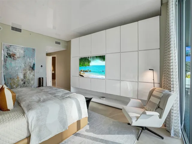 a bedroom with furniture and a large window