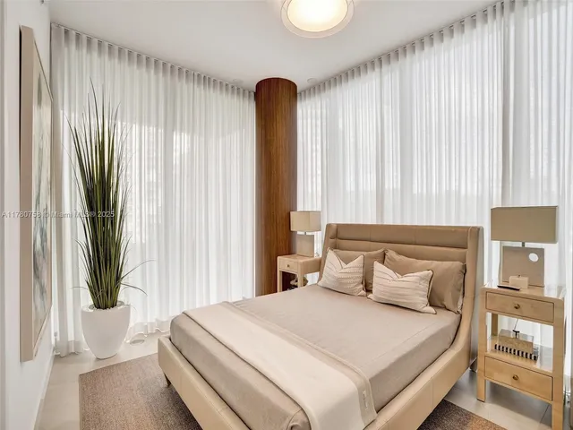 a bedroom with a large bed and a potted plant