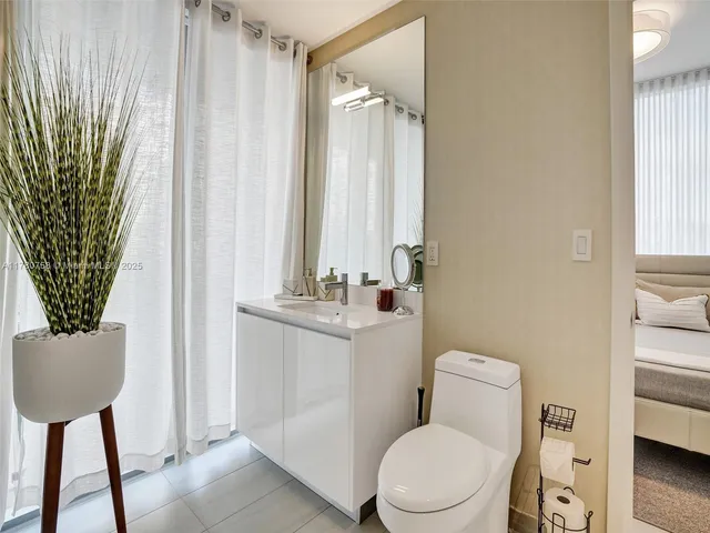 a bedroom with a bed and a potted plant
