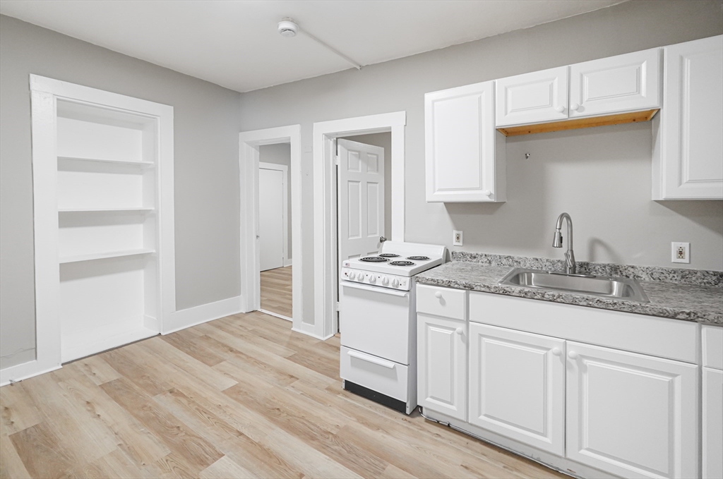 24 Charlton Street, Unit 7 Worcester, MA 01608 - Photo 13 of 17 a kitchen with granite countertop white cabinets and sink