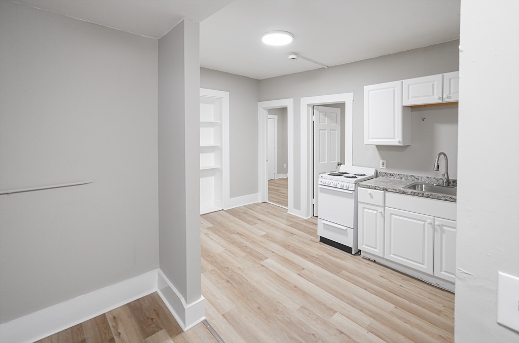 24 Charlton Street, Unit 7 Worcester, MA 01608 - Photo 2 of 17 a kitchen with granite countertop white cabinets and white appliances