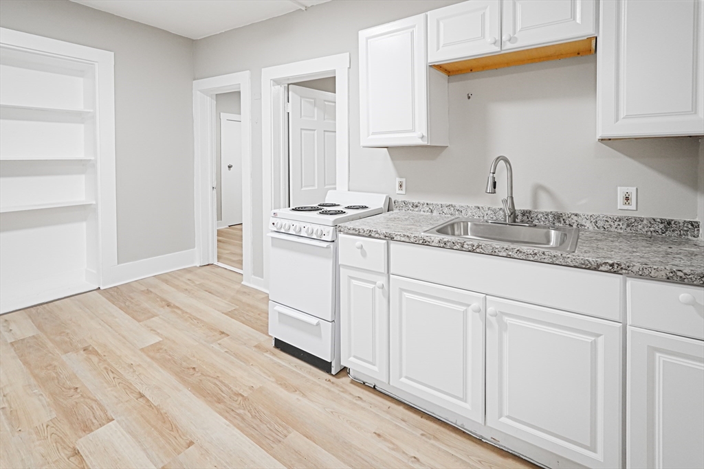 24 Charlton Street, Unit 7 Worcester, MA 01608 - Photo 4 of 17 a kitchen with granite countertop white cabinets and white appliances