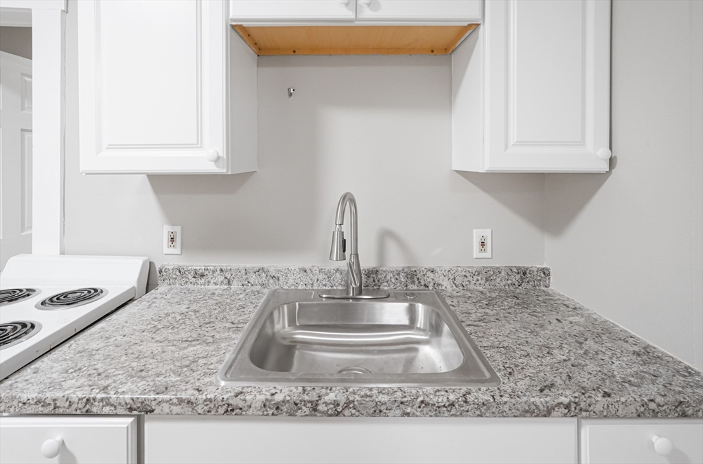 24 Charlton Street, Unit 7 Worcester, MA 01608 - Photo 5 of 17 a kitchen with granite countertop a sink and a stove