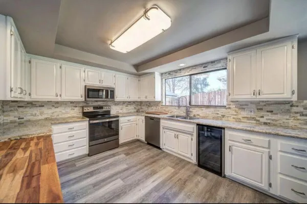 a kitchen with granite countertop white cabinets and appliances