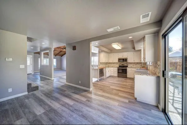 a view of kitchen view wooden floor and appliances