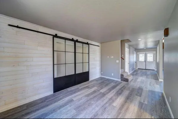 a view of empty room with wooden floor and windows