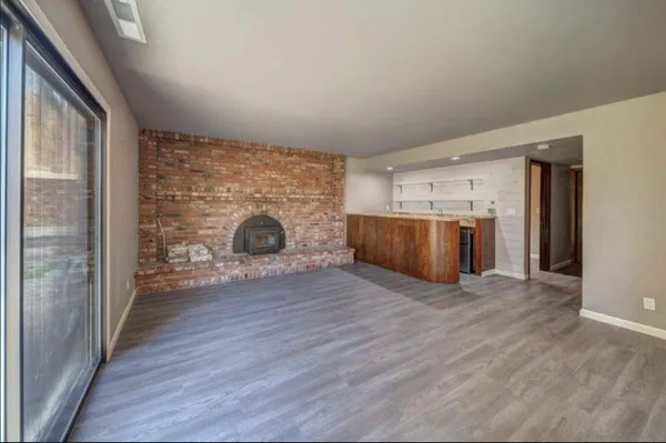 a view of a livingroom with wooden floor and a fireplace