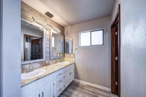 a bathroom with a double vanity sink and a mirror
