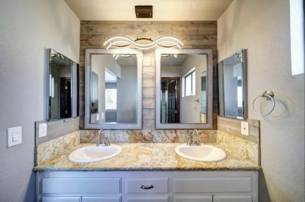 a bathroom with a granite countertop sink and a mirror