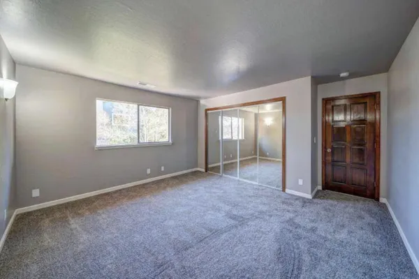 an empty room with windows and closet