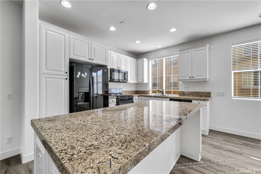 8415 Kendra Loop Orange, CA 92867 - Photo 11 of 36 a large kitchen with kitchen island a sink stove and refrigerator